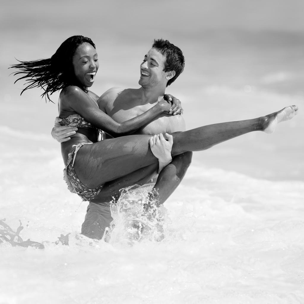 couple having fun in the ocean on their honeymoon