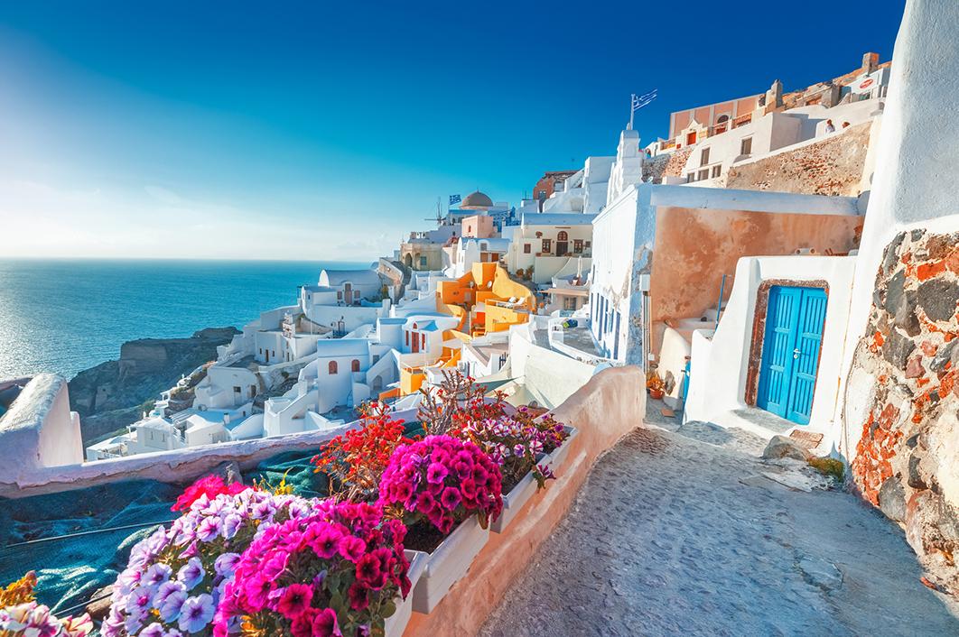 White houses and colorful flowers on the coastline of Santorini