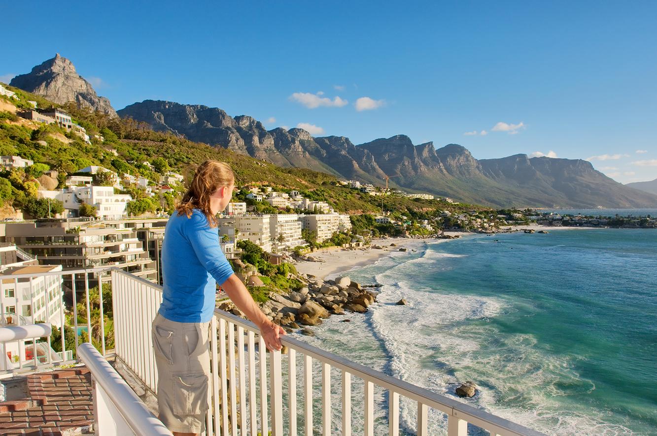 Young adult looking over a beach on a South African tour